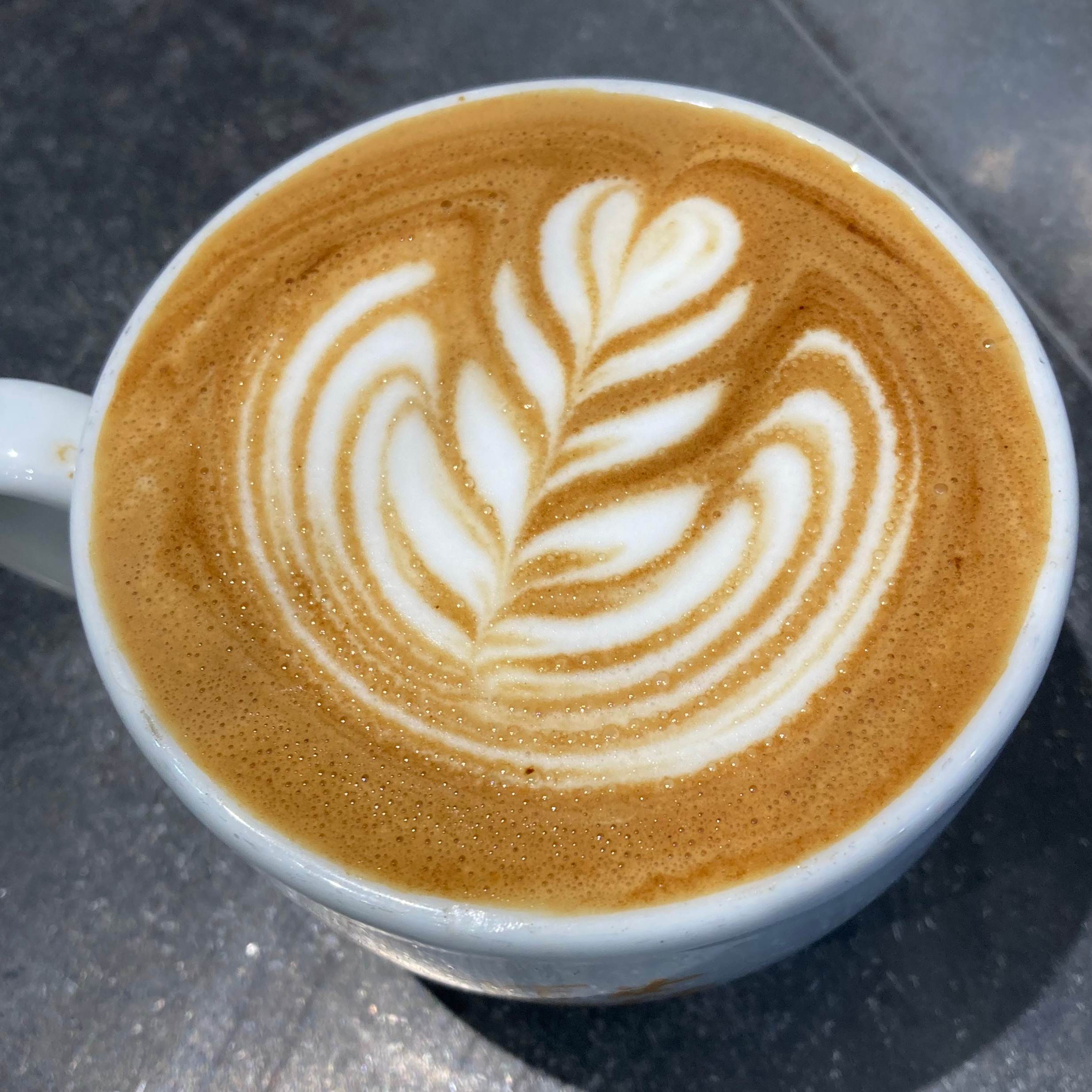 Rosetta latte art in a white cup