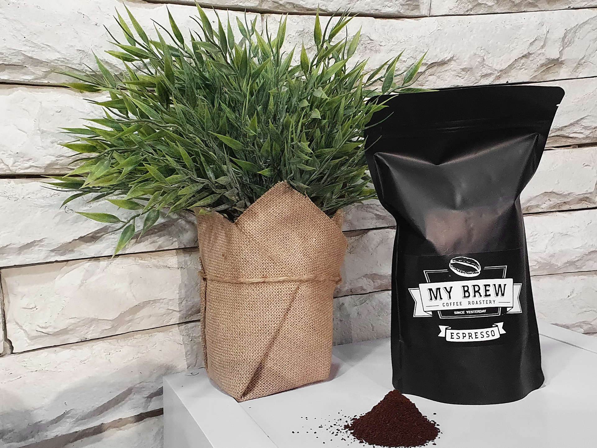 A matte-black bag of My Brew Espresso coffee beside a small pile of ground coffee